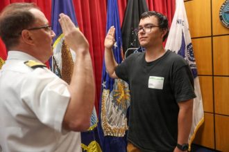 Navy captain gives oath of enlistment to son on last day of service